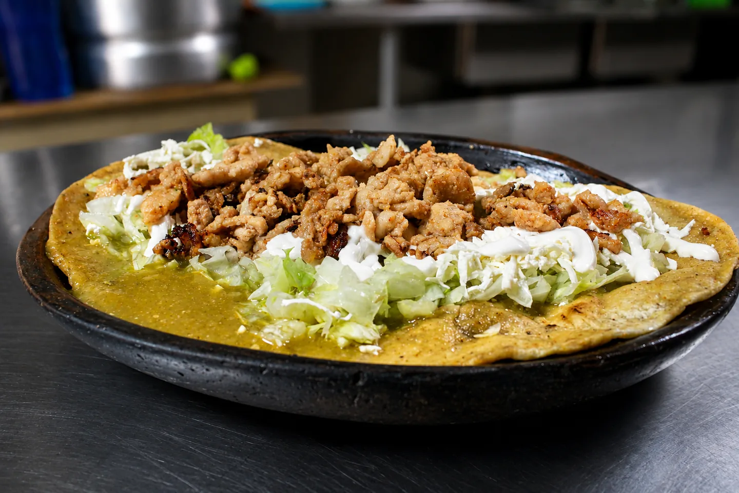 Huarache con pollo, salsa verde, lechuga, crema y queso